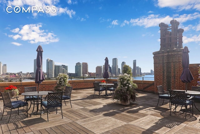 wooden terrace with a view of city and outdoor dining space