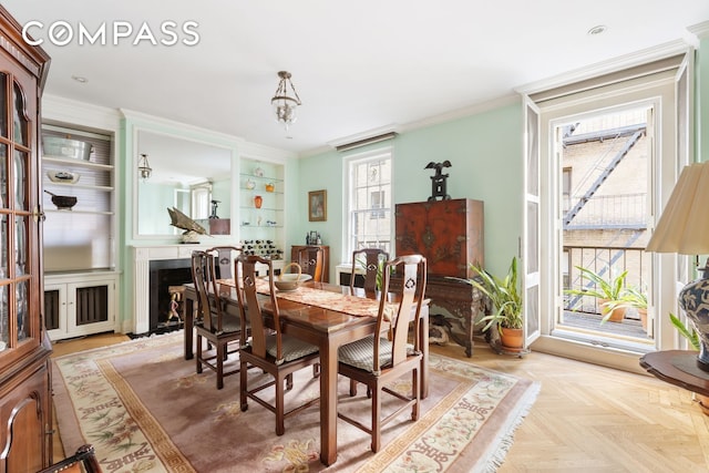 dining room featuring a fireplace and crown molding