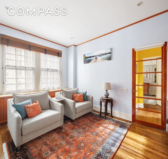 living room featuring ornamental molding, wood finished floors, and baseboards