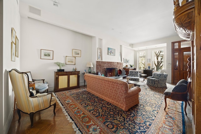 living room featuring visible vents, a premium fireplace, and baseboards