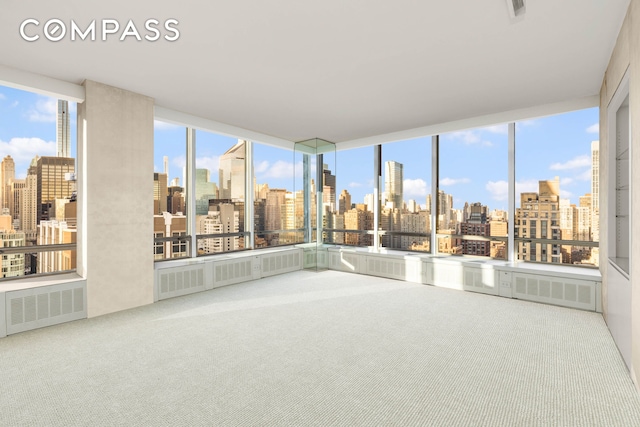 interior space with a view of city, visible vents, and a balcony