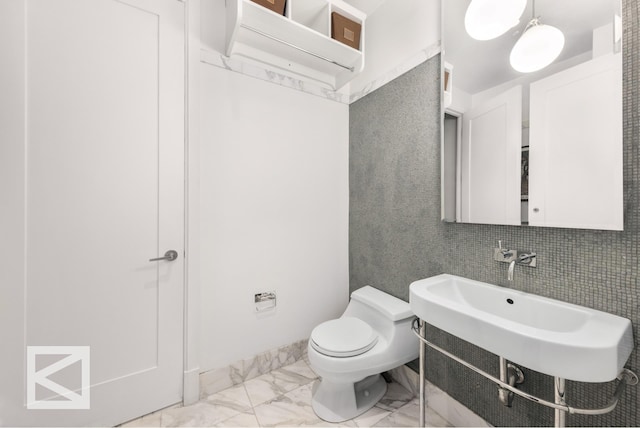 bathroom with marble finish floor and toilet