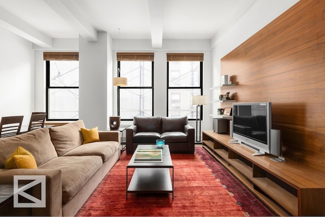 living area with a healthy amount of sunlight and beamed ceiling
