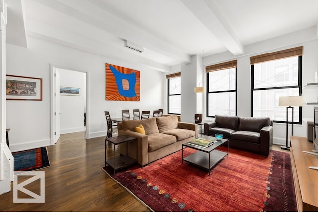 living room with baseboards, beamed ceiling, and wood finished floors