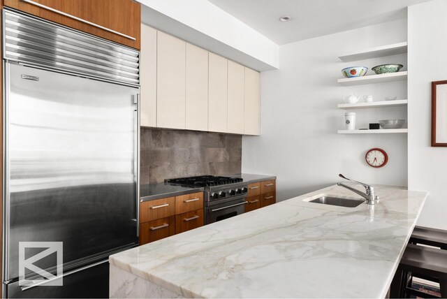 kitchen with dark wood-style flooring, open floor plan, a sink, light stone countertops, and built in microwave