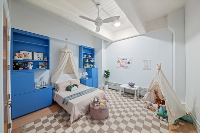 bedroom featuring ceiling fan, wood finished floors, and beam ceiling