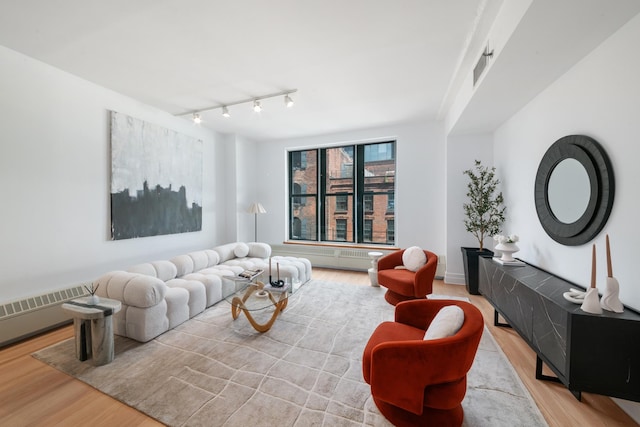 living room with rail lighting and wood finished floors