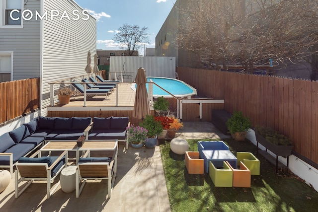 view of patio / terrace with a fenced in pool, a fenced backyard, and an outdoor living space