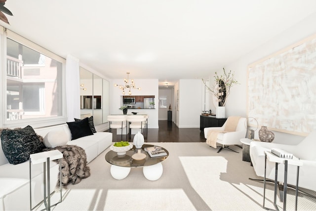 living area with a notable chandelier and dark wood finished floors