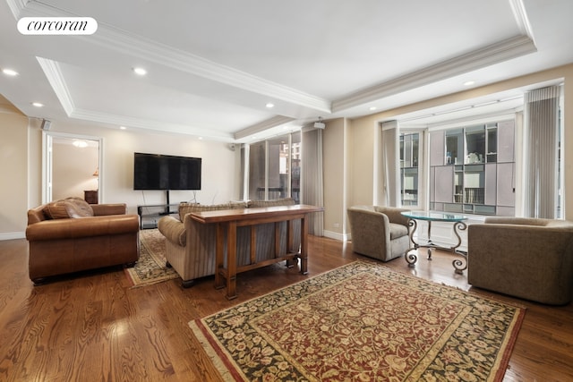 living room featuring visible vents, a tray ceiling, wood finished floors, and ornamental molding