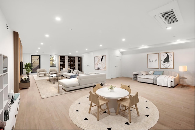 living room with recessed lighting, visible vents, and light wood-style flooring