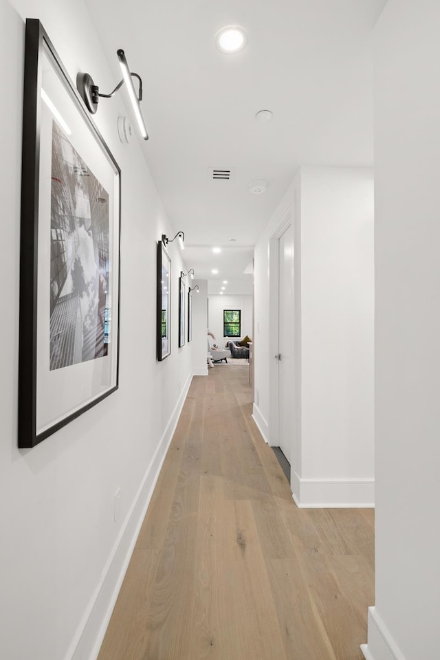 corridor with recessed lighting, baseboards, and light wood finished floors