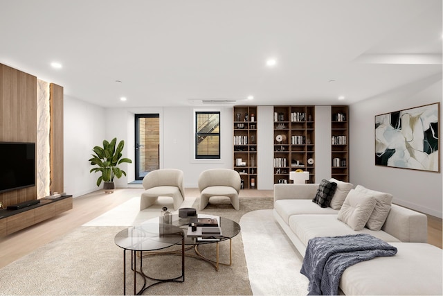 living area with baseboards, light wood-style flooring, and recessed lighting