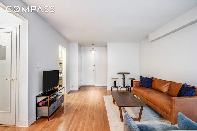 living area with light wood-style flooring and baseboards