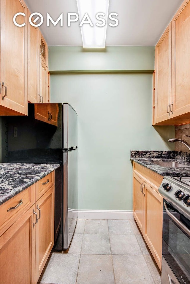 305 E 72nd St Unit 4Cn, New York City, NY 10021 - kitchen with dark stone counters, light brown cabinets, appliances with stainless steel finishes, and baseboards