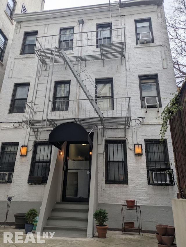 view of front of house with cooling unit and a balcony