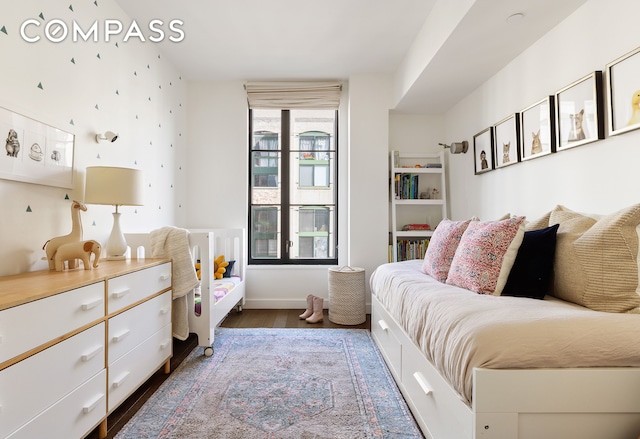 bedroom with dark wood-style floors and baseboards