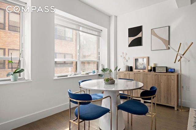 dining space with a wealth of natural light, baseboards, and wood finished floors