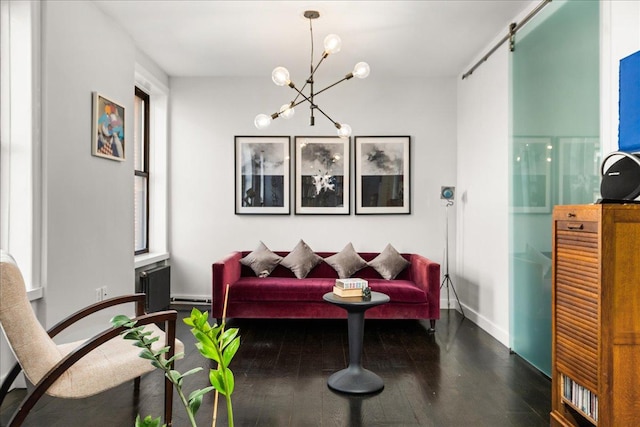 sitting room featuring a notable chandelier, baseboards, and wood finished floors