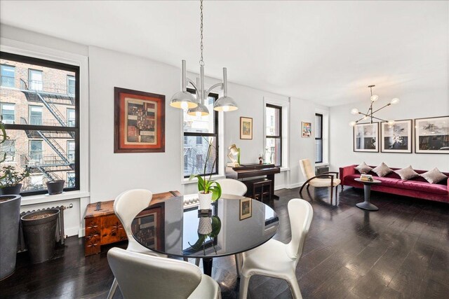 dining room with dark wood finished floors and a notable chandelier