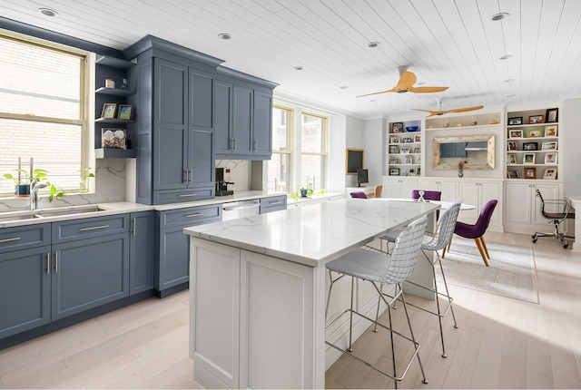 kitchen featuring dishwasher, wooden ceiling, a sink, and a kitchen breakfast bar