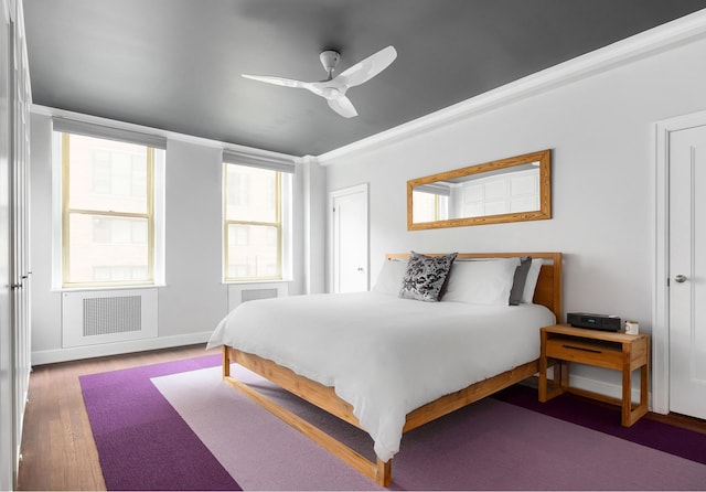 bedroom featuring ceiling fan, baseboards, and wood finished floors