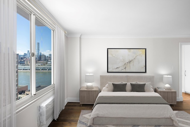 bedroom with crown molding, baseboards, a city view, and wood finished floors