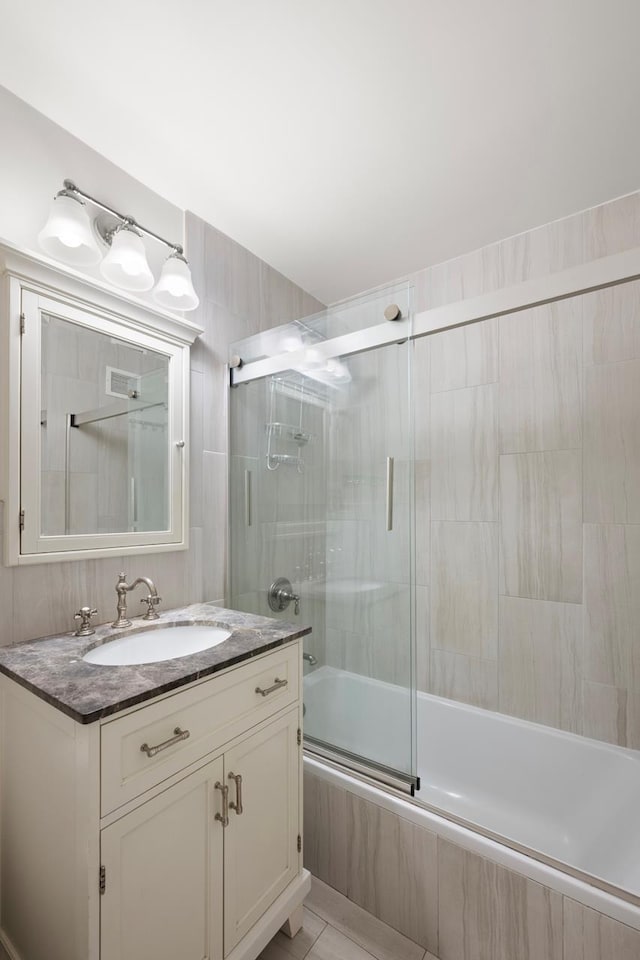 full bath featuring vanity, visible vents, and tiled shower / bath combo