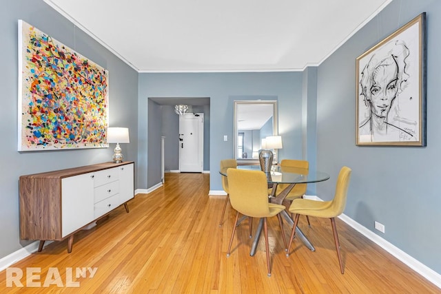 dining space featuring baseboards, crown molding, and hardwood / wood-style floors