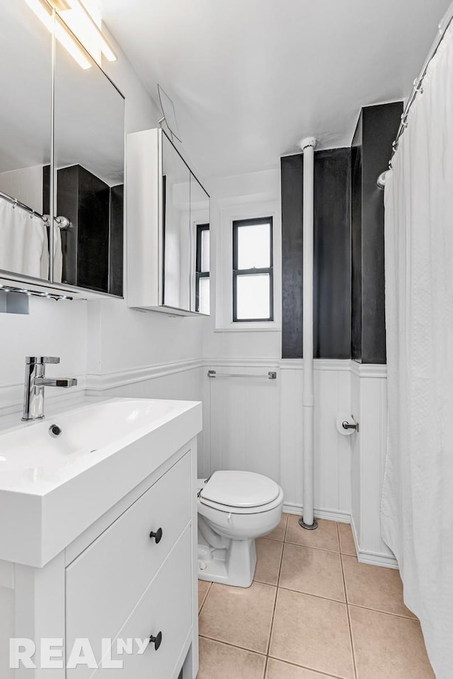 full bathroom with toilet, a wainscoted wall, vanity, and tile patterned floors