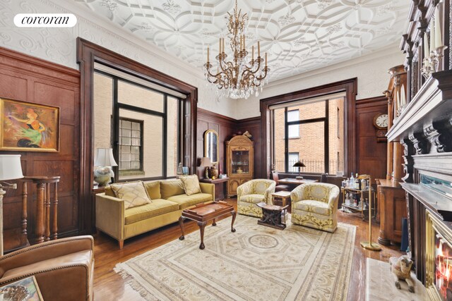 sitting room featuring visible vents, wood finished floors, crown molding, a fireplace, and a chandelier