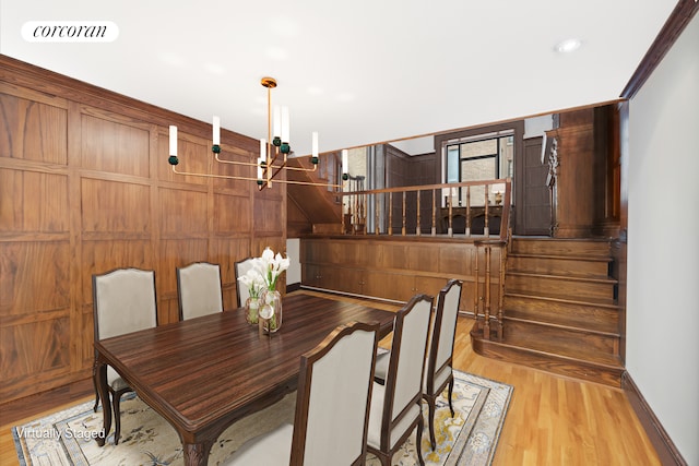 dining room featuring visible vents, wood walls, stairway, and wood finished floors