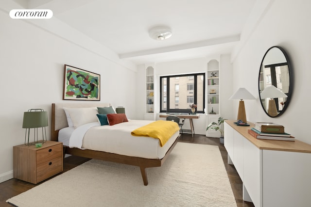 bedroom featuring beamed ceiling, dark wood finished floors, and visible vents