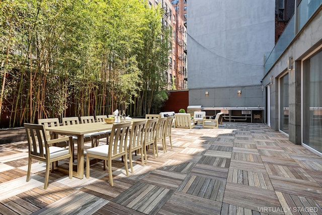 wooden deck with outdoor dining space and grilling area