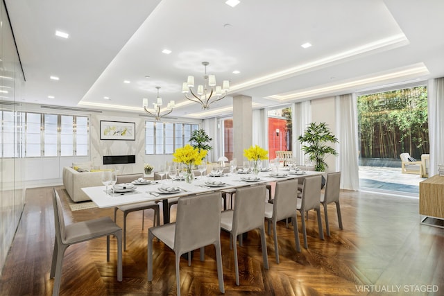 dining room featuring recessed lighting, a raised ceiling, and a notable chandelier