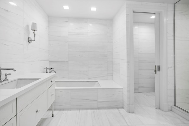 bathroom featuring vanity, tile walls, a shower stall, and a bathing tub