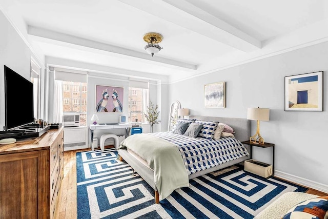 bedroom featuring cooling unit, beam ceiling, baseboards, and wood finished floors