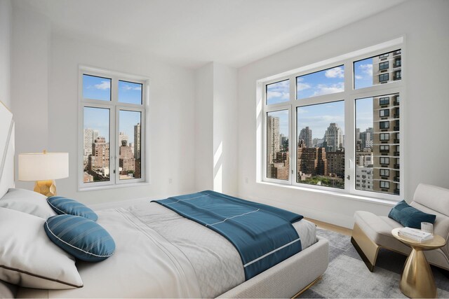 bedroom featuring a city view and wood finished floors