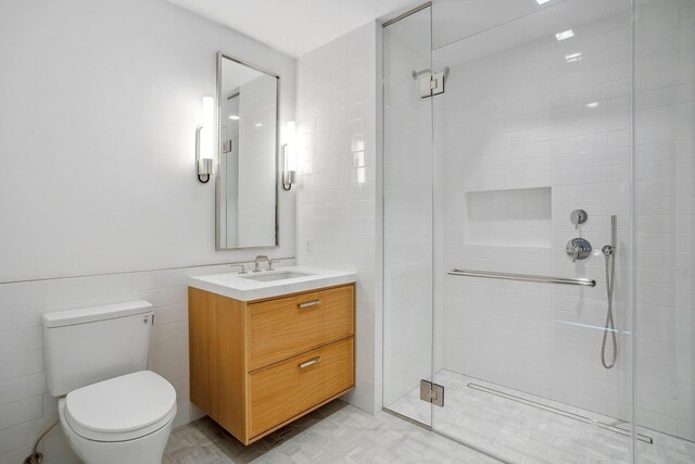 bathroom featuring toilet, a stall shower, and vanity