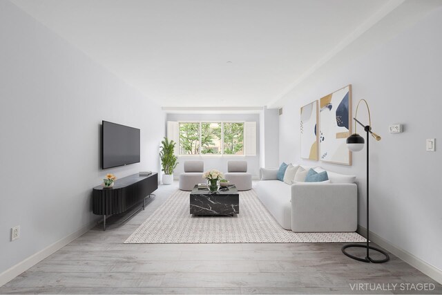 living area with baseboards and wood finished floors