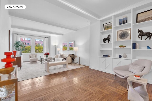 sitting room featuring baseboards, visible vents, beamed ceiling, crown molding, and built in shelves