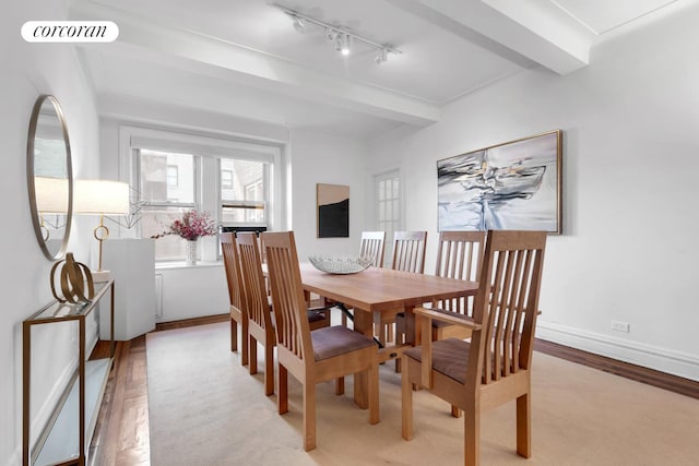 dining area with visible vents, baseboards, beamed ceiling, rail lighting, and light wood-style floors