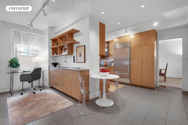 kitchen featuring open shelves, rail lighting, visible vents, wall chimney range hood, and built in refrigerator