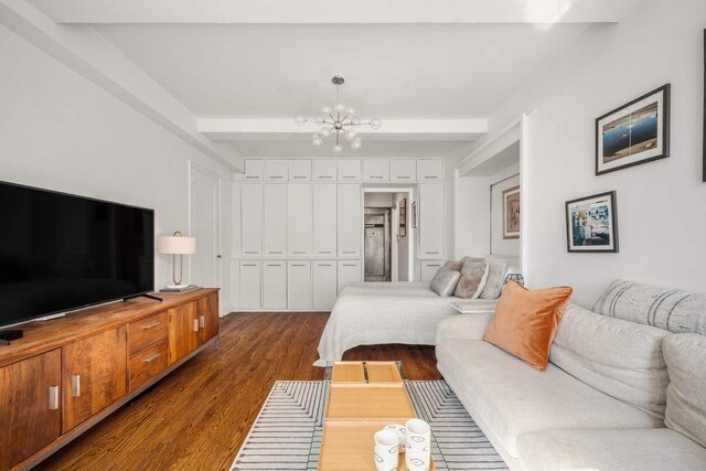 bedroom featuring a closet, a chandelier, dark wood-type flooring, and beam ceiling