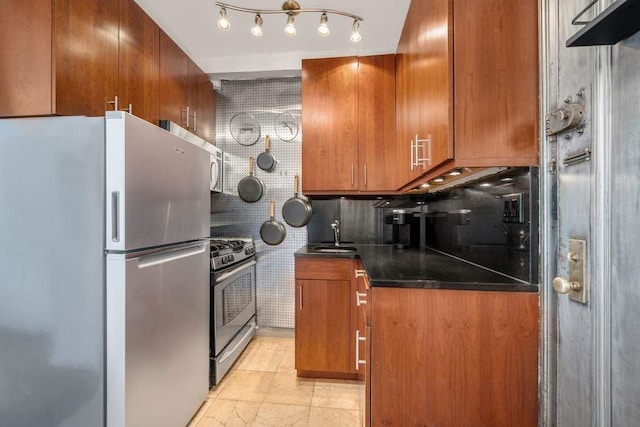 kitchen featuring stainless steel appliances, brown cabinetry, dark countertops, and backsplash