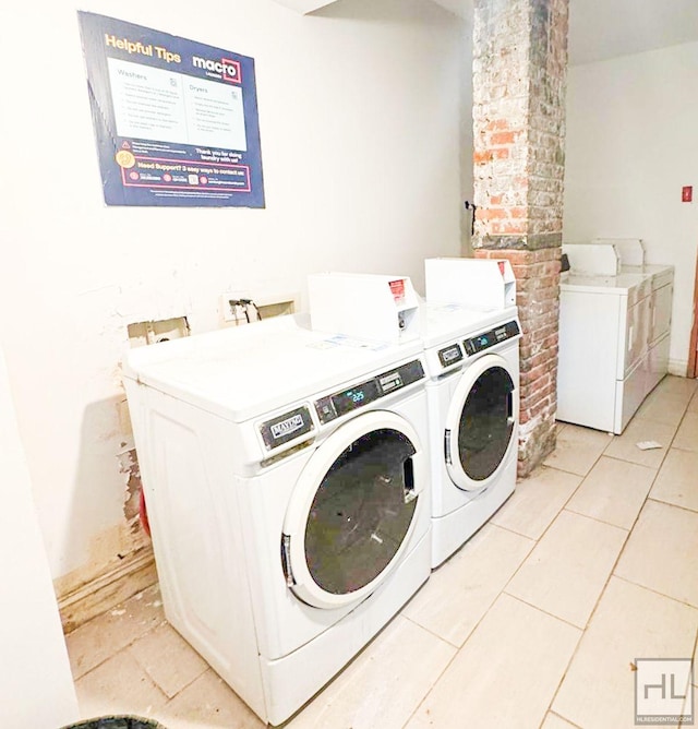 common laundry area featuring washing machine and clothes dryer and light tile patterned floors