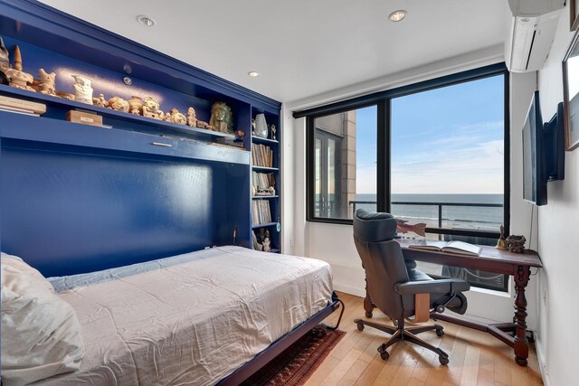 91-16 Shore Front Pkwy Unit 6H, New York City, NY 11693 - bedroom with hardwood / wood-style floors, a wall mounted air conditioner, recessed lighting, and baseboards