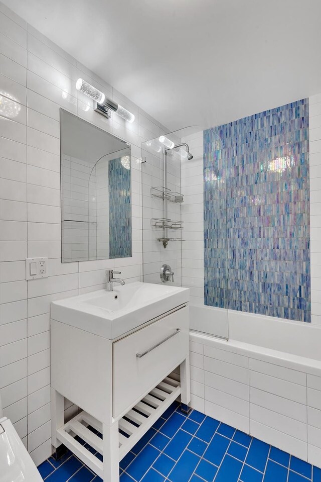 91-16 Shore Front Pkwy Unit 6H, New York City, NY 11693 - bathroom featuring tile patterned flooring, tile walls, tiled shower / bath, and vanity