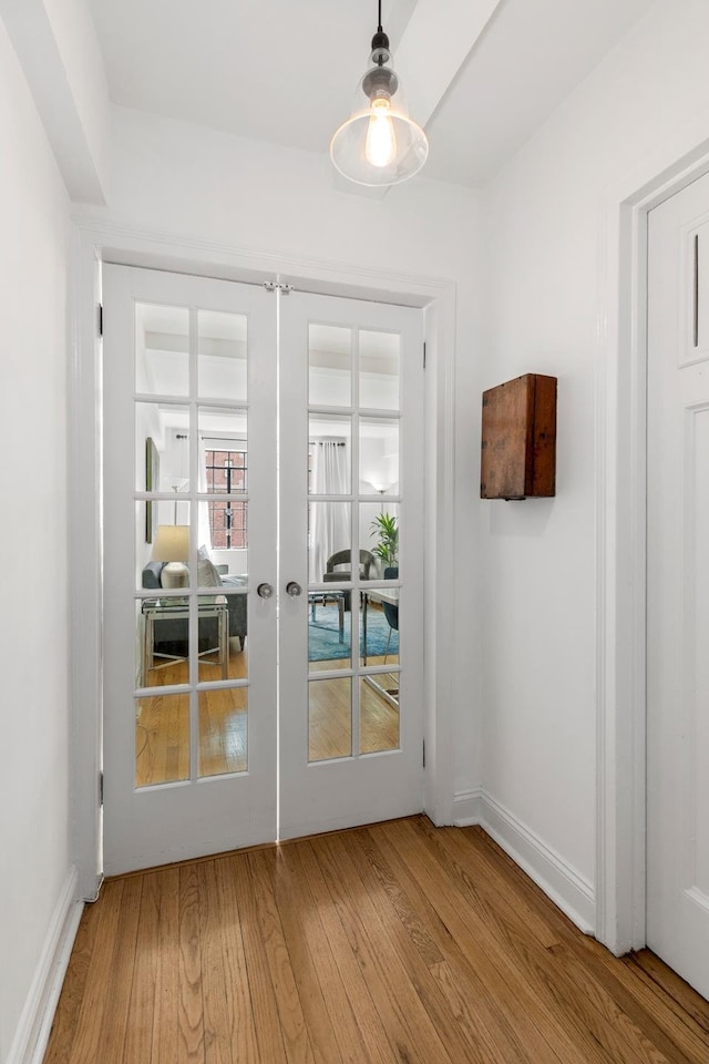 doorway to outside with wood finished floors, french doors, and baseboards