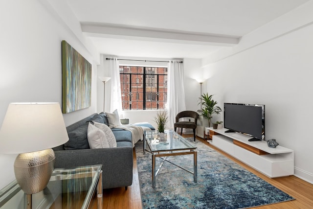 living room featuring wood finished floors, beamed ceiling, and baseboards